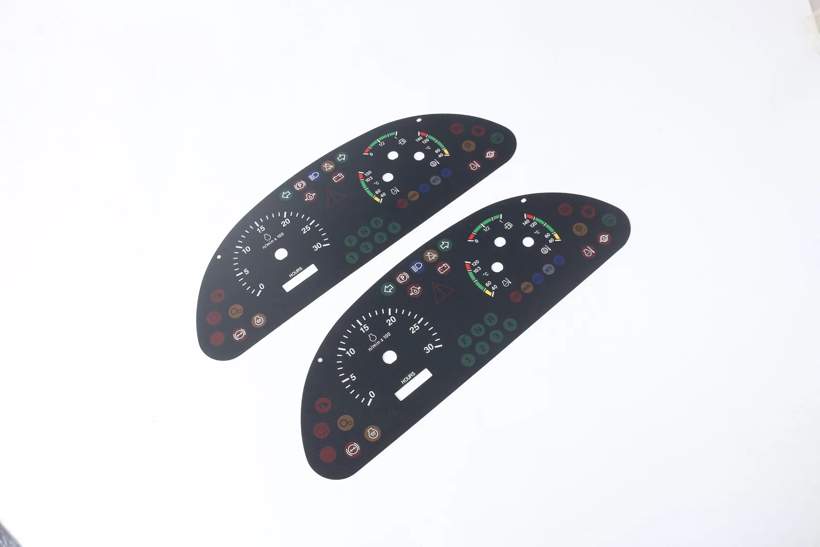 Two automotive instrument overlays with printed scales, indicator icon zones, pointer openings and display windows