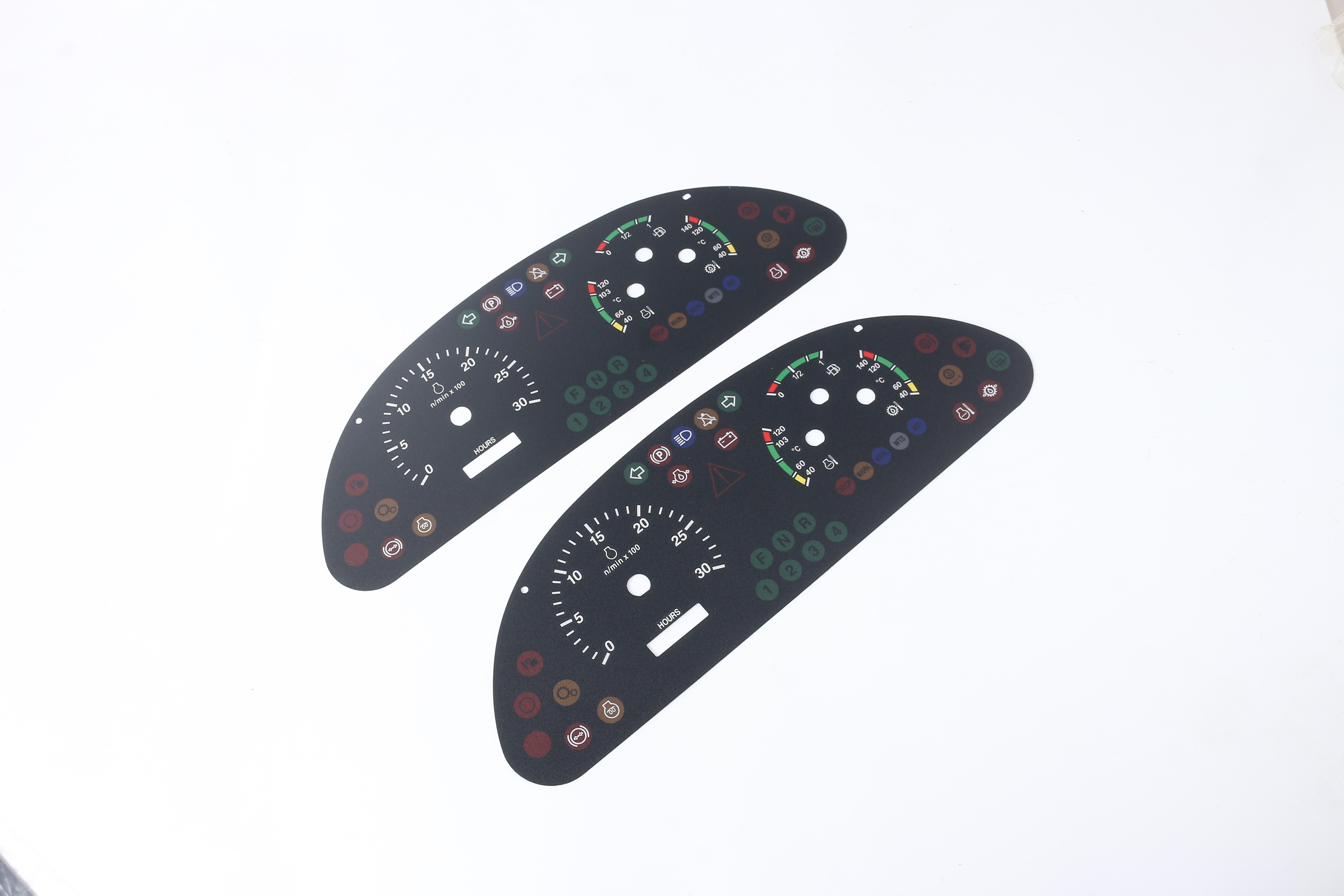 Two automotive instrument overlays with printed scales, indicator icon zones, pointer openings and display windows